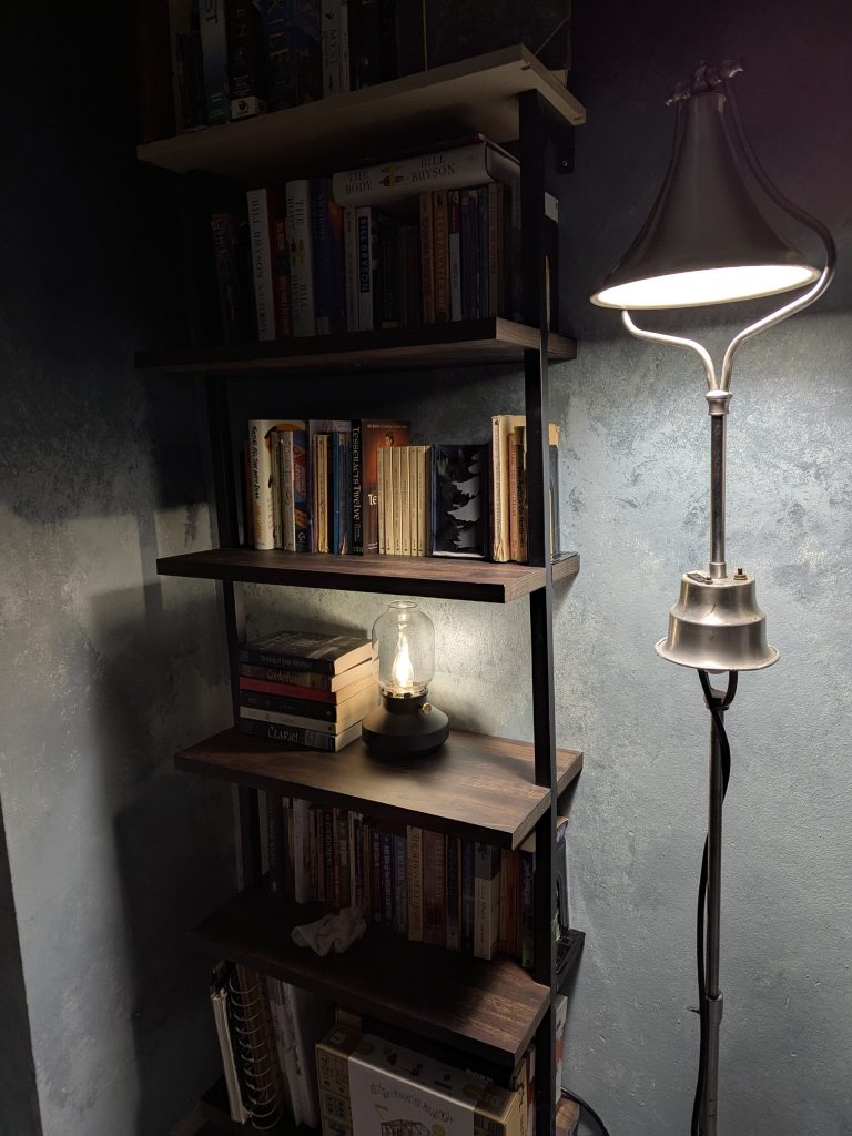 The reading nook, showing off the walls painted to look like rustic/faded plaster, my fiction bookshelf, and a vintage doctor's lamp from the 1930s.